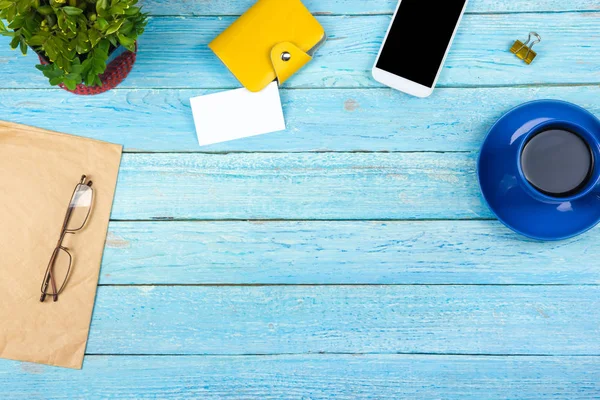 Blauer Schreibtisch mit Computer, Stift und einer Tasse Kaffee, viele Dinge. Draufsicht mit Kopierraum. — Stockfoto