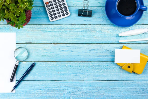 Mesa de escritório azul com computador, caneta e uma xícara de café, muitas coisas. Vista superior com espaço de cópia. — Fotografia de Stock