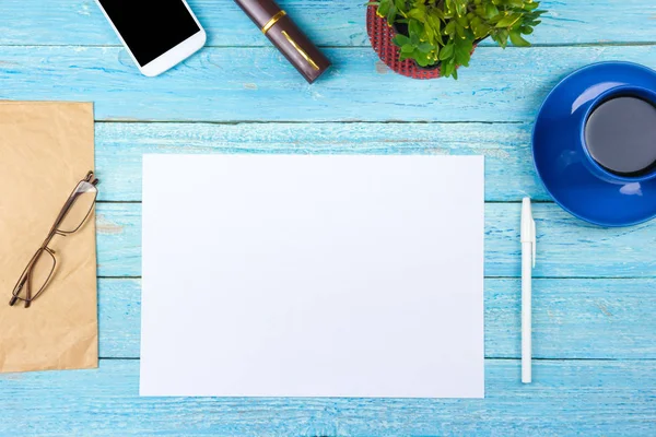 Blauer Schreibtisch mit Computer, Stift und einer Tasse Kaffee, viele Dinge. Draufsicht mit Kopierraum. — Stockfoto