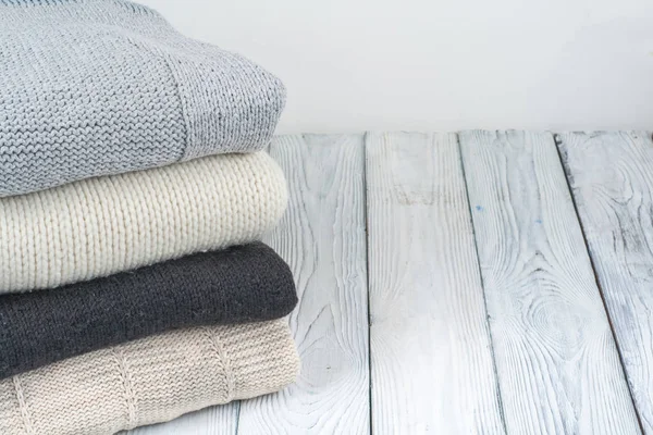 Örgü yün kazaklar. Ahşap arka planda örülmüş kış kıyafetleri, kazaklar, örgü giysileri, metin için yer..