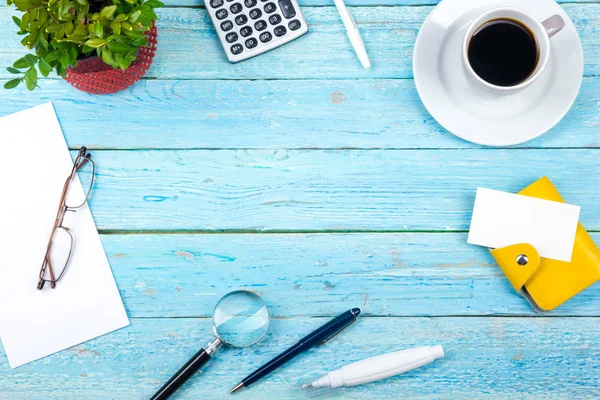 Mesa de escritório azul com computador, caneta e uma xícara de café, muitas coisas. Vista superior com espaço de cópia. — Fotografia de Stock