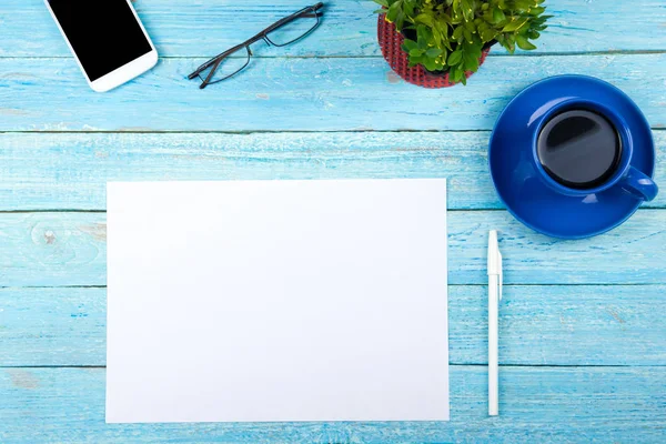 Blauer Schreibtisch mit Computer, Stift und einer Tasse Kaffee, viele Dinge. Draufsicht mit Kopierraum. — Stockfoto