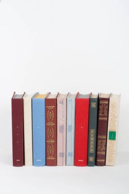 Kitap istifleme. Açık bir kitap, ahşap masada ciltli kitaplar ve...