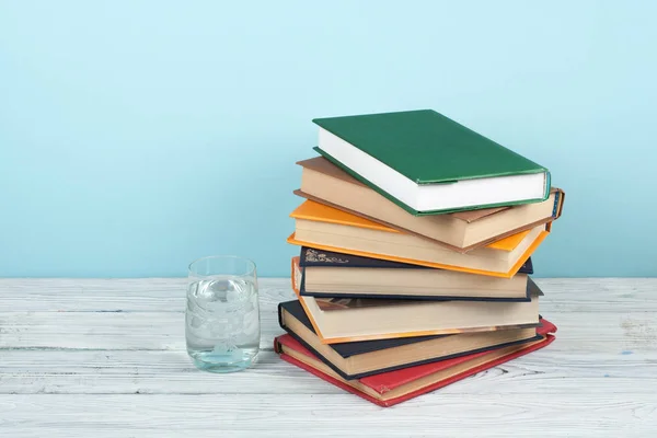 Apilamiento de libros. Libro abierto, libros de tapa dura sobre mesa de madera y fondo verde. De vuelta a la escuela. Copiar espacio para texto. — Foto de Stock