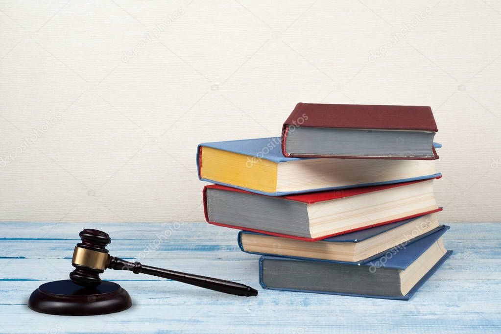 Law concept open book with wooden judges gavel on table in a courtroom or law enforcement office, beige background. Copy space for text.
