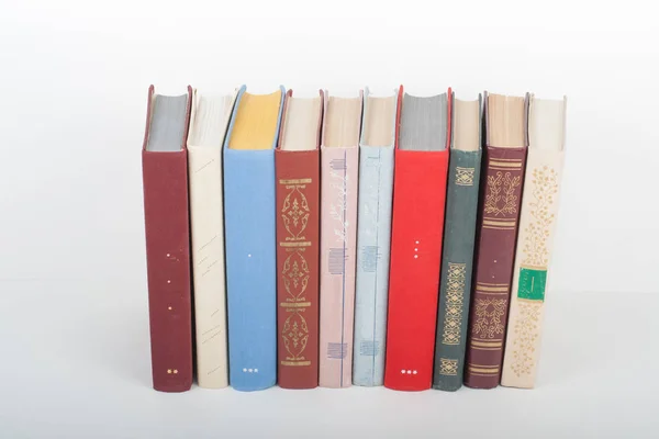 Bücherstapeln. Aufgeschlagenes Buch, gebundene Bücher auf Holztisch und weißem Hintergrund. Zurück zur Schule. Kopierraum für Text — Stockfoto