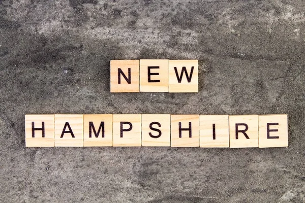 New Hampshire Słowo Napisane Bloku Drewna Szarym Tle Betonu Widok — Zdjęcie stockowe