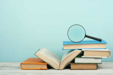 Açık kitap, ahşap masa üzerinde renkli ciltli kitap. Büyüteç'i. Okula dönüş. Metin için yer kopyalayın. Eğitim iş kavramı