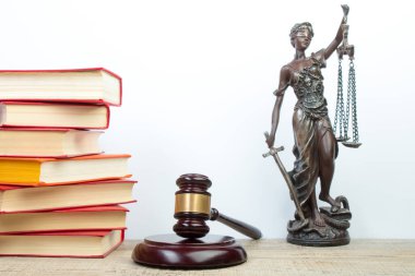 Hukuk konsepti - açık hukuk kitabı, yargıç tokmağı, teraziler, mahkeme salonundaki ya da kolluk kuvvetlerindeki heykel. Tahta masa, beyaz arkaplan.