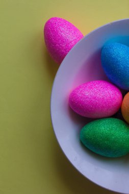 Bir tabak içinde renkli Paskalya yumurtaları