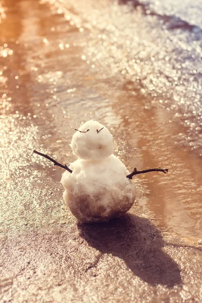 水たまりの背景に雪だるま — ストック写真