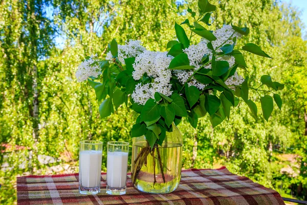 Birkaç kurabiye, bardak süt ve çiçekler
