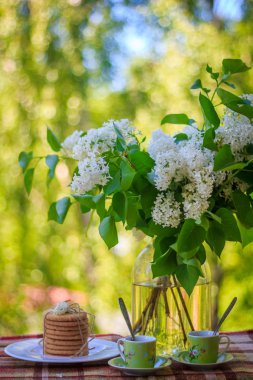 Bardak çay bisküvi ile bir Vazoda Çiçekler