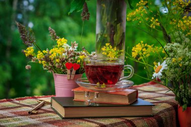 Bir fincan çay ve kır çiçekleri pembe demir kova