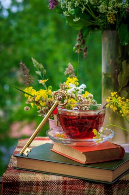 Bir fincan çay ve kır çiçekleri pembe demir kova