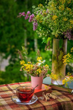 Bir fincan çay ve kır çiçekleri pembe demir kova