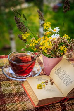 Bir fincan çay ve kır çiçekleri pembe demir kova