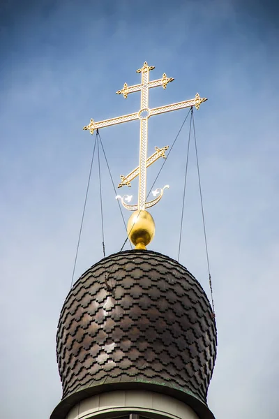 Cruz dorada en la cúpula del templo. Cruz de oro en un cielo azul — Foto de Stock
