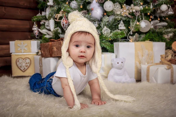 Bebê em traje de elfo brincando com trem de madeira velho e ursos de brinquedo macios sob a árvore de Natal, vintage . — Fotografia de Stock