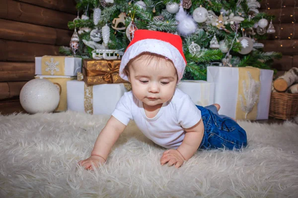 Bebé en traje de elfo jugando con el viejo tren de madera y los osos de juguete suave bajo el árbol de Navidad, vintage . —  Fotos de Stock