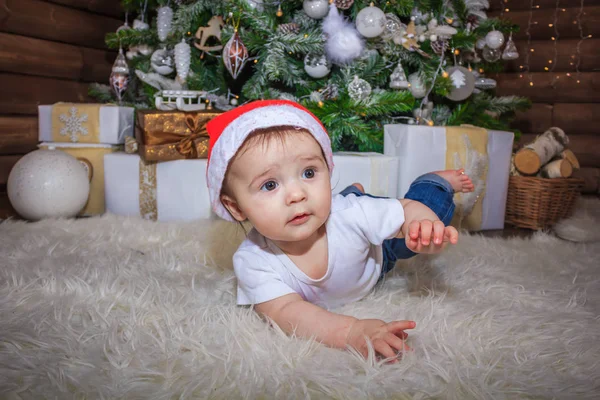 Bebé en traje de elfo jugando con el viejo tren de madera y los osos de juguete suave bajo el árbol de Navidad, vintage . —  Fotos de Stock