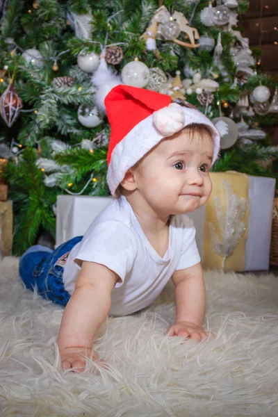 Bebê em traje de elfo brincando com trem de madeira velho e ursos de brinquedo macios sob a árvore de Natal, vintage . — Fotografia de Stock