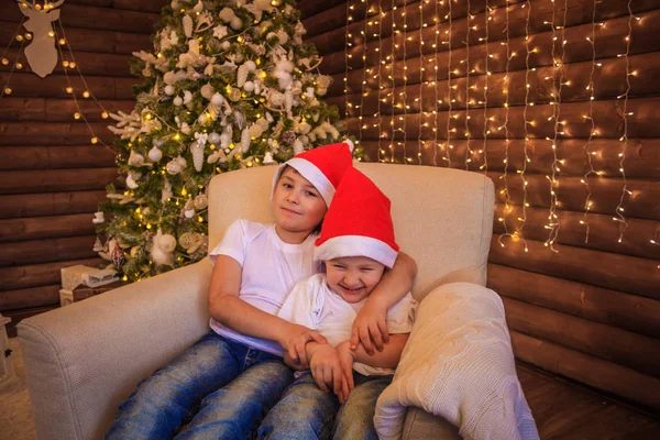 Zwei Süße Jungen Brüder Auf Der Couch Die Weihnachtsmannmützen Tragen — Stockfoto