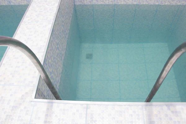 The pool is small in the building. Descent to the pool. Square pool