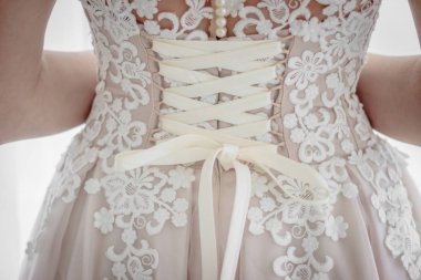 pencere arka planda beyaz elbiseli saç modeli ile gelinin arka görünümü 