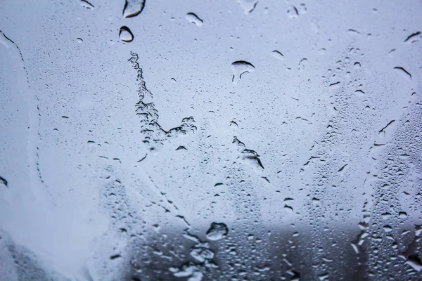 Drops of water on the glass. Background of water drops flowing down the glass. Texture of water droplets. Natural water, wet drops