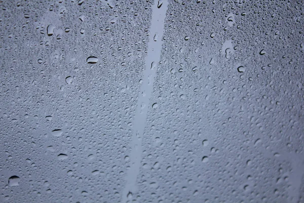 Drops of water on the glass. Background of water drops flowing down the glass. Texture of water droplets. Natural water, wet drops