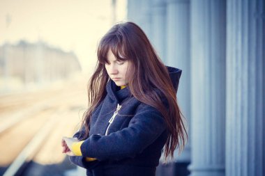 Gündüz vakti tren istasyonunda poz veren genç bir kadın