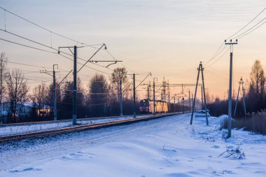 Demiryolunda Rus treni, gün batımında kış manzarası