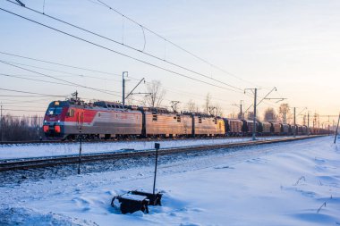 Demiryolunda Rus treni, gün batımında kış manzarası