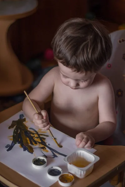 Cute child painting with brush at home