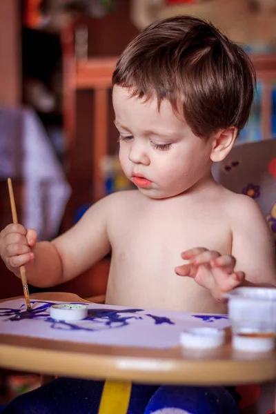 Cute child painting with brush at home