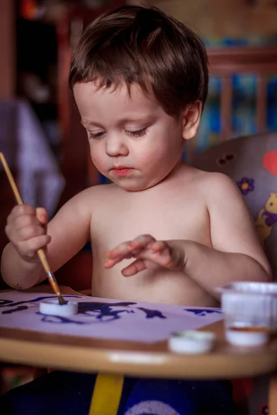 Cute child painting with brush at home