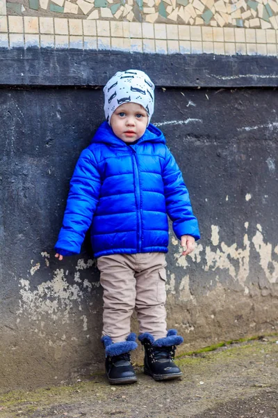建筑背景上穿蓝色夹克的小男孩的户外肖像 — 图库照片