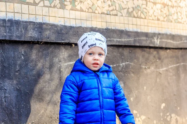建筑背景上穿蓝色夹克的小男孩的户外肖像 — 图库照片