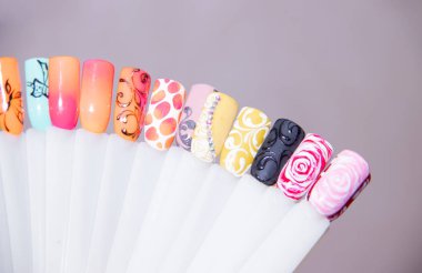 Tırnak bakımı ve manikür kavramı. İstemcinin çivi seçimi için çok renkli oje paleti. Kadın güzellik salonu. Boşaltmak için metin