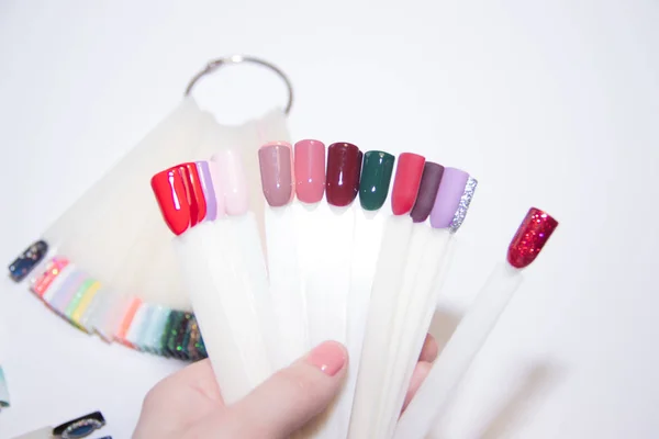 Cuidado de uñas y concepto de manicura. Paleta de esmalte de uñas multicolor para elegir las uñas del cliente. Mujer en el salón de belleza. Copyspace para texto —  Fotos de Stock