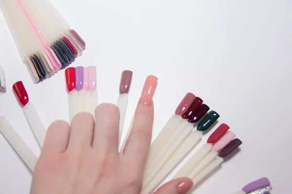 Cuidado de uñas y concepto de manicura. Paleta de esmalte de uñas multicolor para elegir las uñas del cliente. Mujer en el salón de belleza. Copyspace para texto —  Fotos de Stock