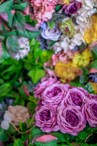 Background of pink and yellow paper flowers. Artificial flowers. Floral background. Kraft paper