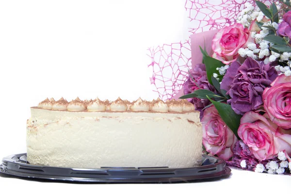 白い背景に隔離されたピンクの花のおいしいティラミスケーキと花束 — ストック写真