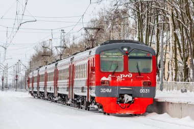 Kış ormanı boyunca raylı kırmızı Rus treni, Rusya, Leningrad bölgesi, Gatchina bölgesi, 26 Aralık 2018