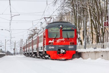 Kış ormanı boyunca raylı kırmızı Rus treni, Rusya, Leningrad bölgesi, Gatchina bölgesi, 26 Aralık 2018