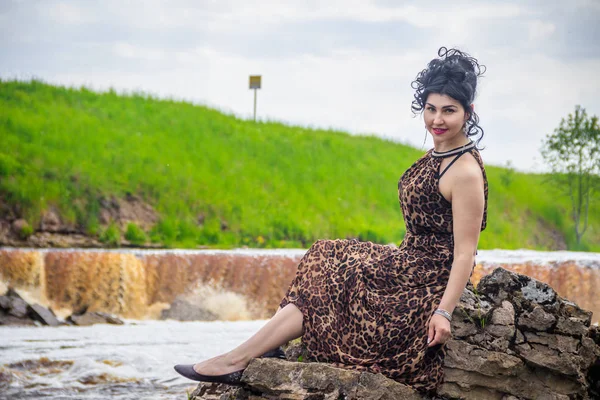 Woman on the waterfalls. Little waterfall. Camping. . Young woman. Woman in a dress.