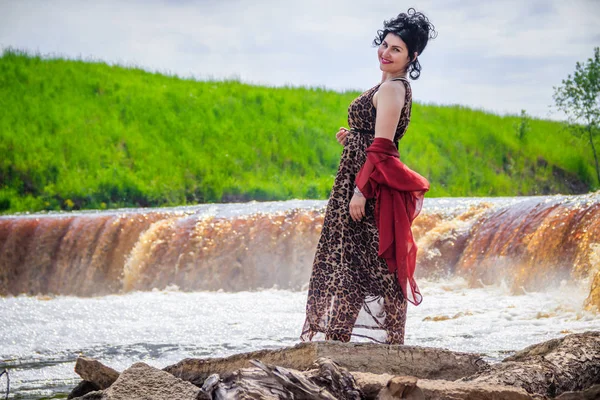 Woman on the waterfalls. Little waterfall. Camping. . Young woman. Woman in a dress.