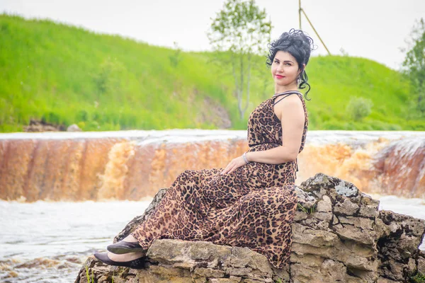 Woman on the waterfalls. Little waterfall. Camping. . Young woman. Woman in a dress.