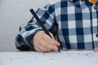 Küçük çocuk kağıt üzerinde keçeli kalemlerle çizim. Gelişimsel faaliyetler. 